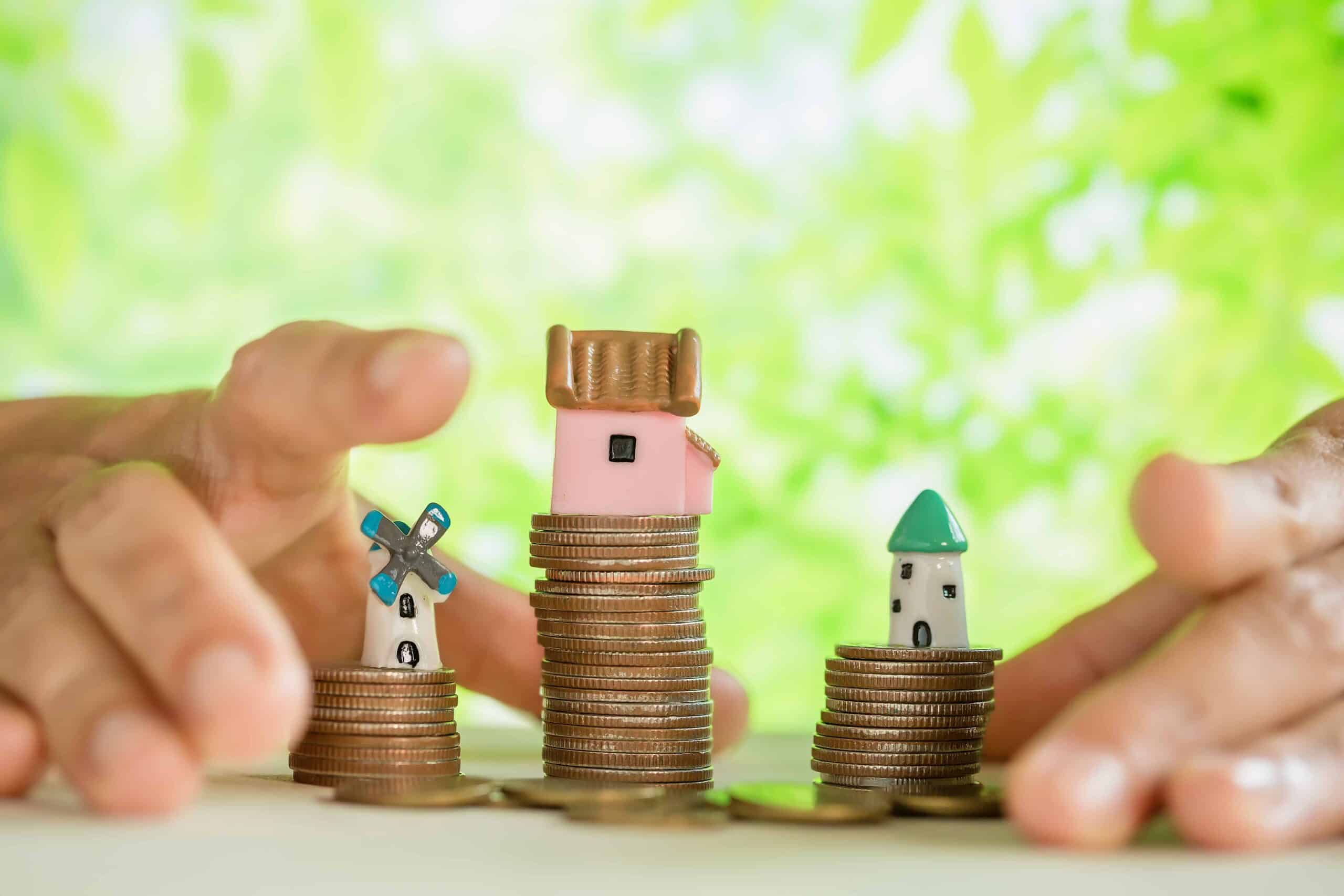 Graphic related to increasing property value. Minature homes stacked on coins.
