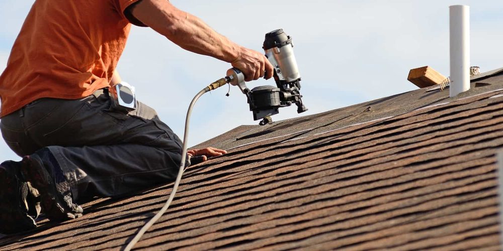 Roofing contractor repairing roof