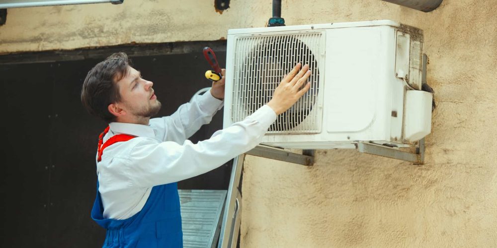 HVAC techinician performing maintenance on AC Unite