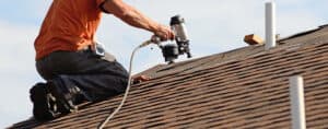 Roofing contractor repairing roof